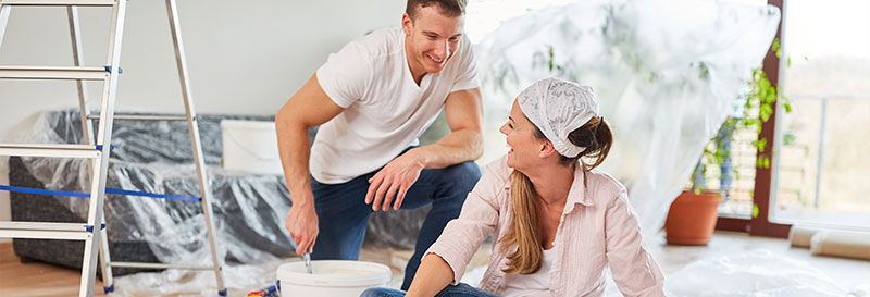 Couple smiling with decorating equipment around them