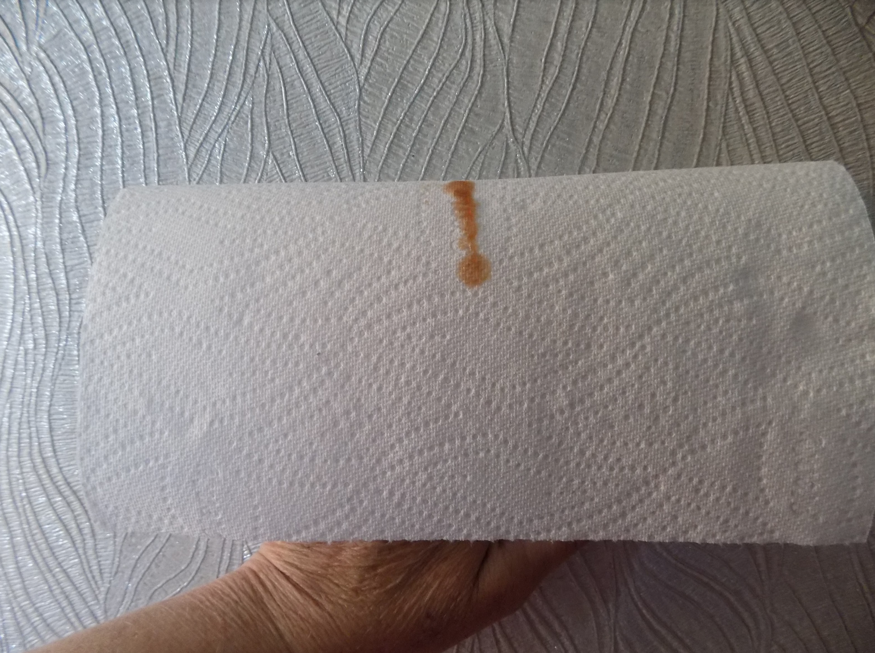 kitchen roll with grease against wallpaper